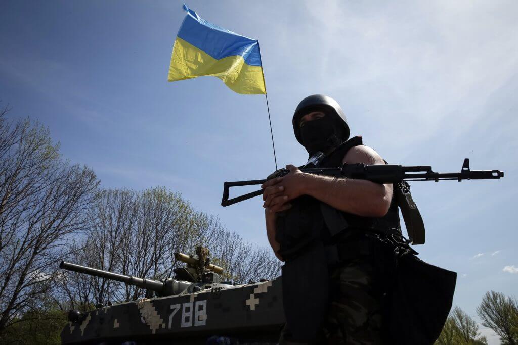 A Ukrainian soldier stands guard near an APC at a checkpoint outside the city of Slaviansk