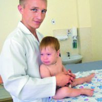 Фізичний реабілітолог Олександр Павленко із маленьким пацієнтом