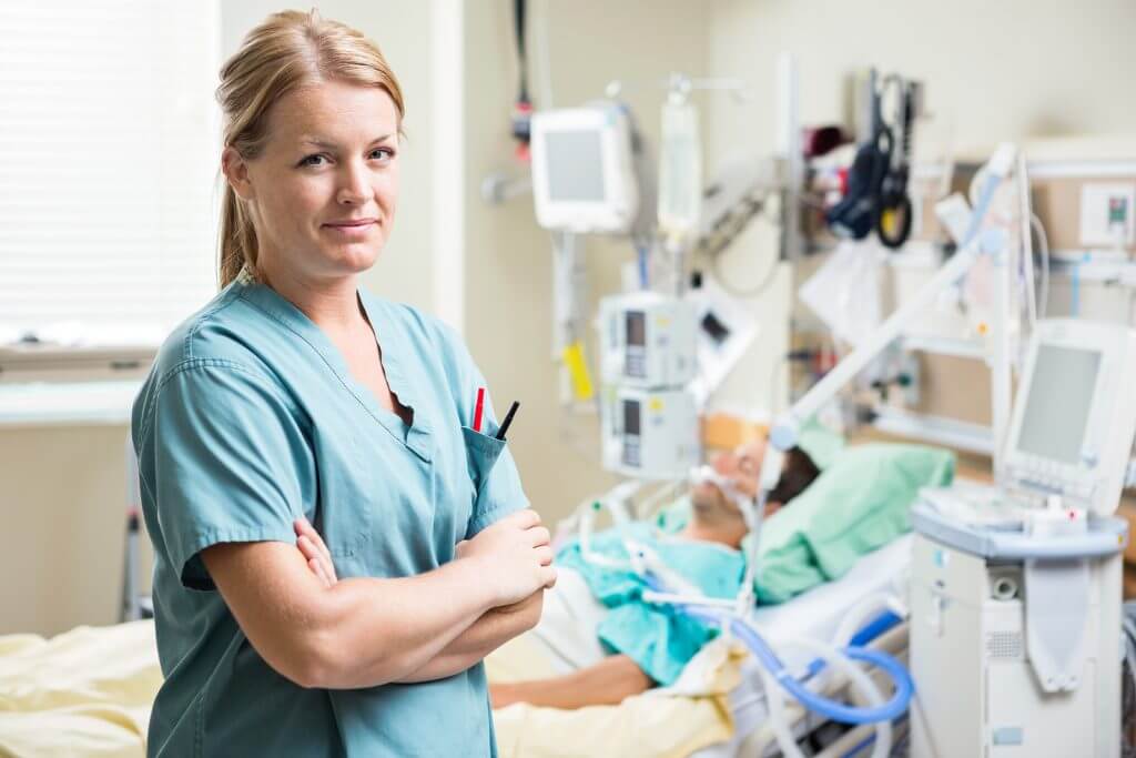 Portrait of confident nurse standing arms crossed with patient r